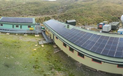 An array of solar panels on top of the roofs of two buildings