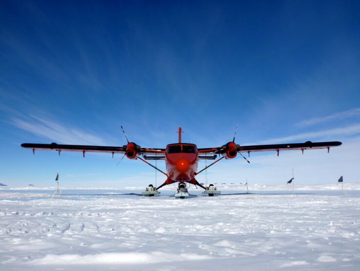 A Twin Otter aircraft with skis on ice