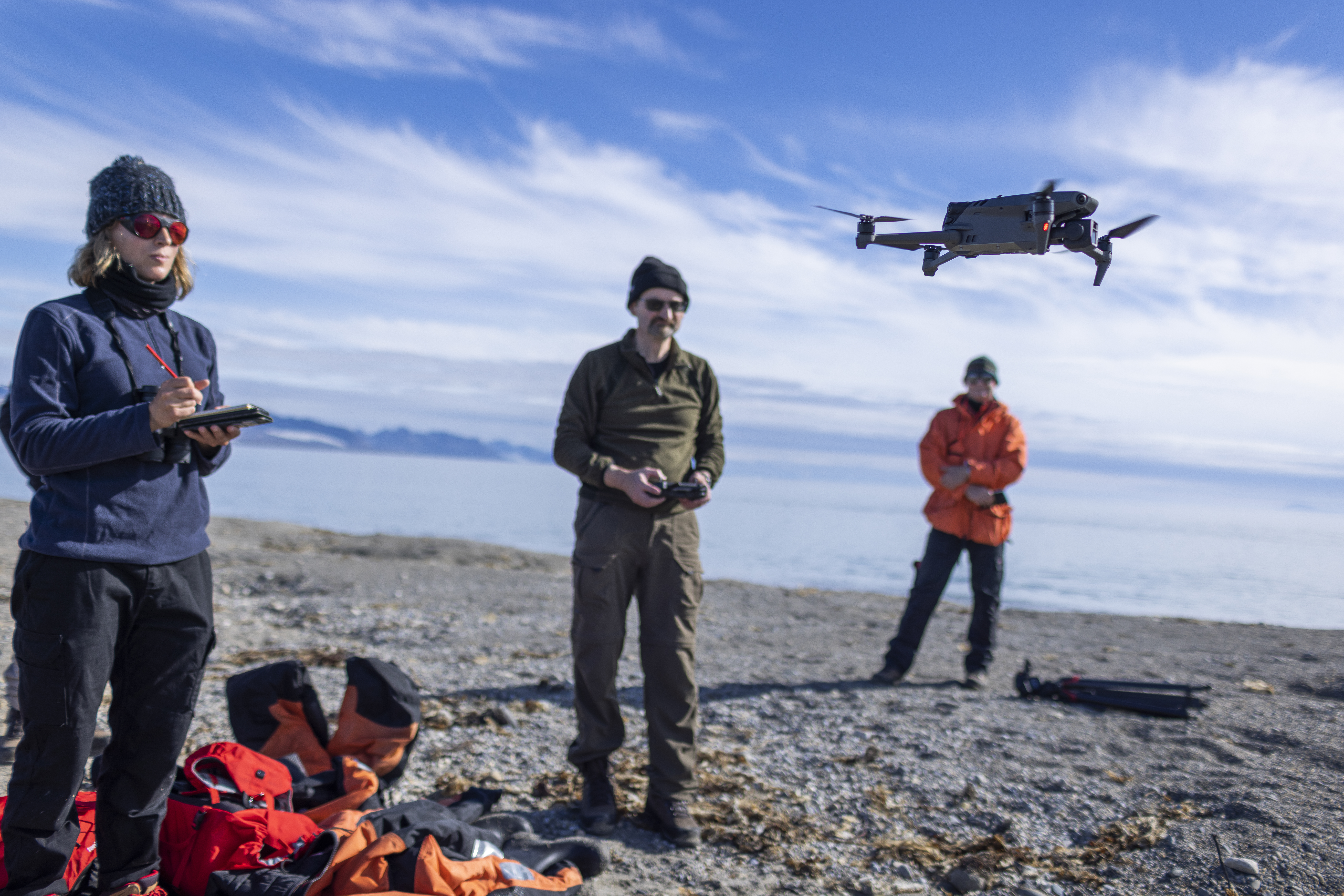 Three people flying a drone