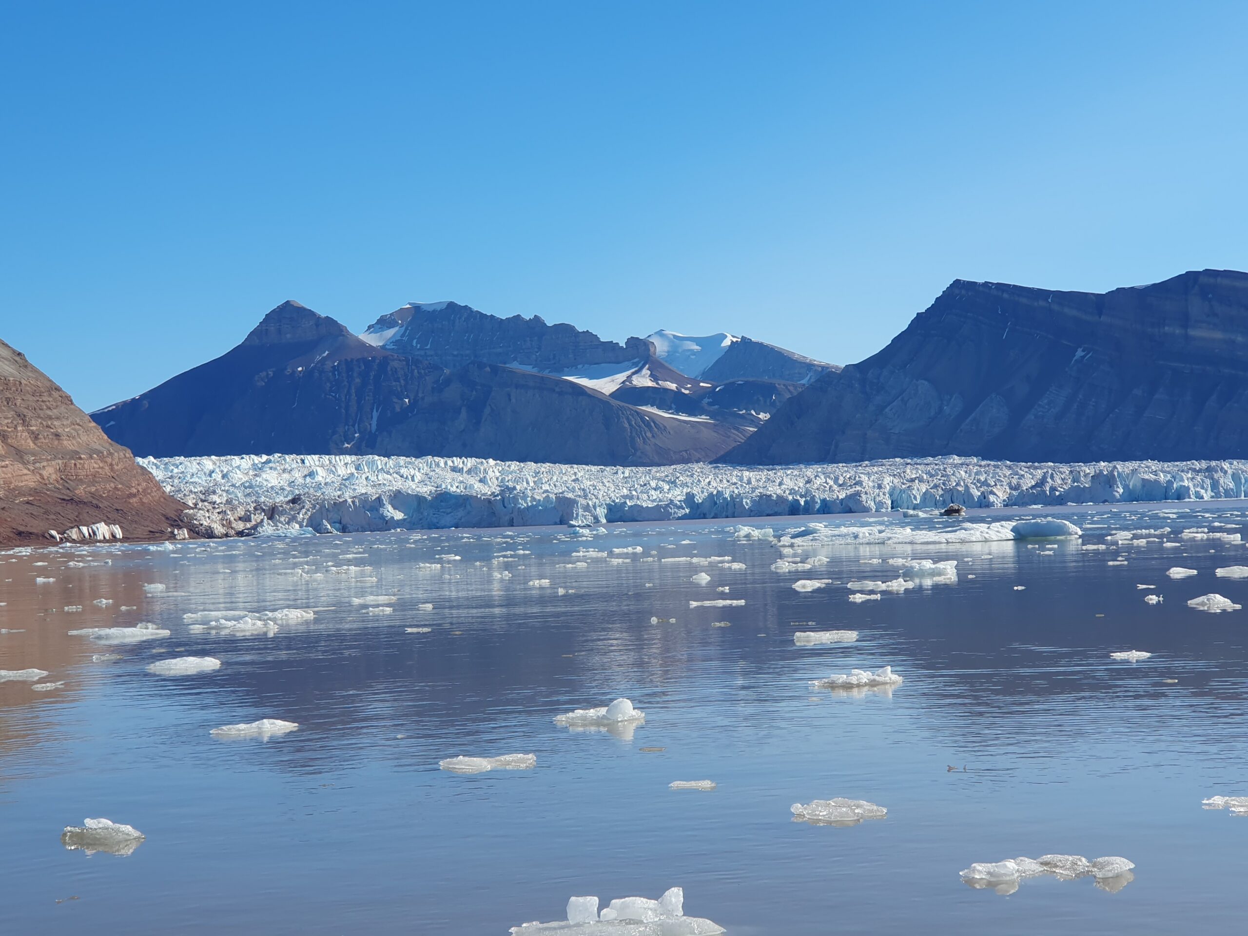 A body of water with a mountain in the background