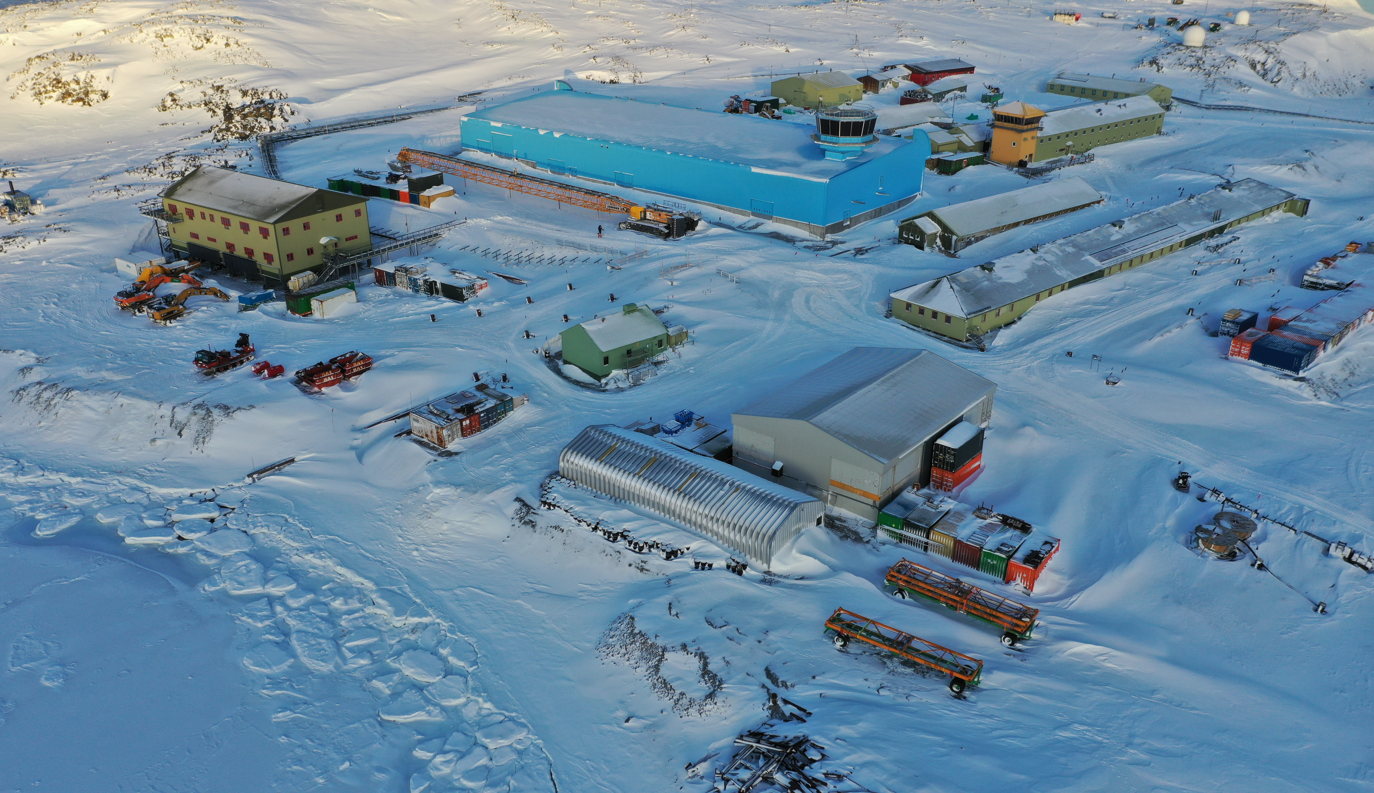 A complex of buildings surrounded by snow, including a large blue building - called the Discovery Building. The buildings -of different sizes, designs and colours, have a light dusting of snow on their roofs