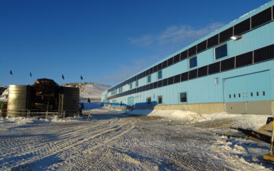 Photo of a snowy building in Antarctica with solar panels installed