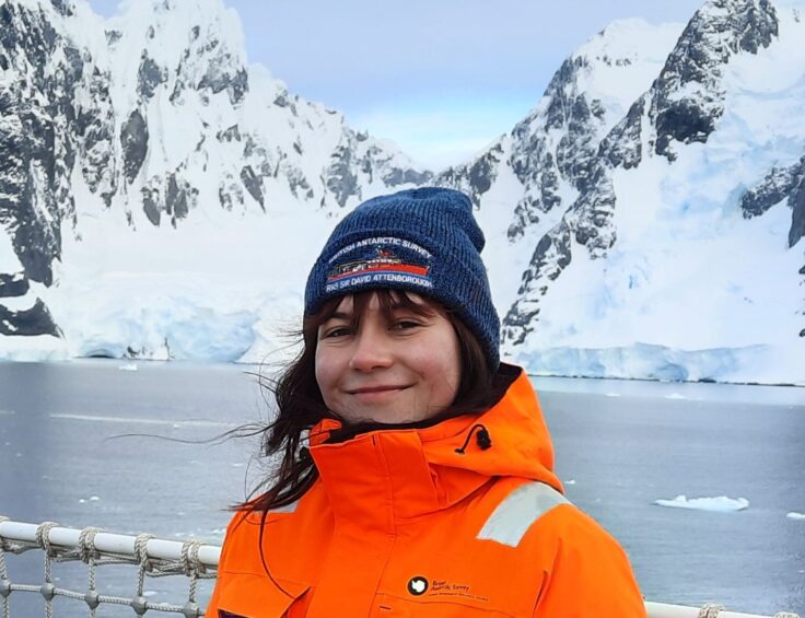 A person standing in front of a snow covered mountain