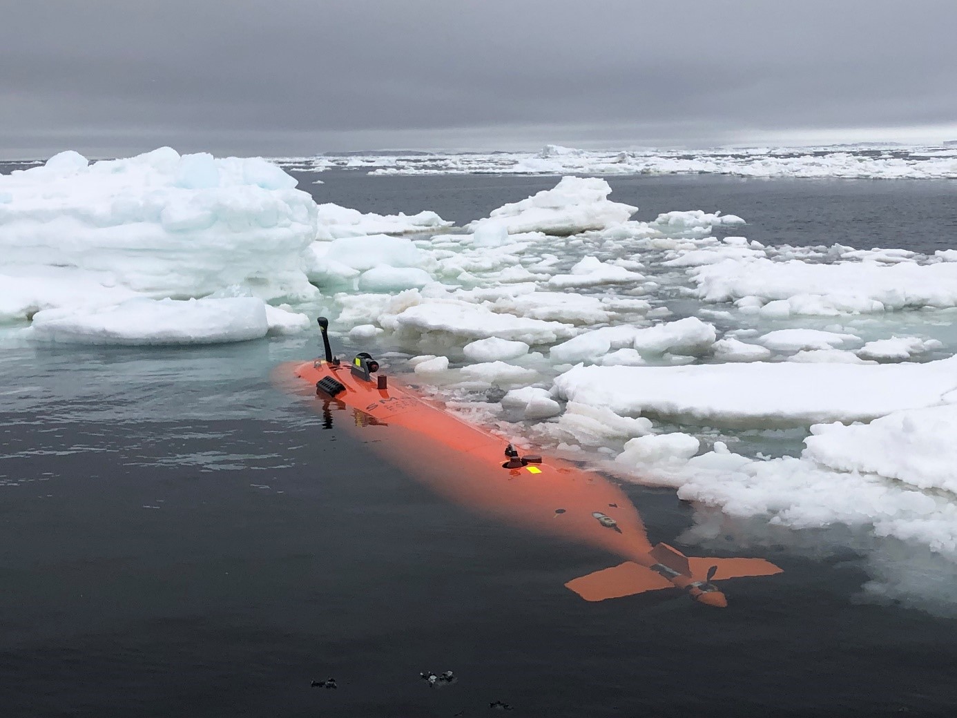 An orange marine robot in icy water