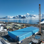 A large blue building with a snow covered mountain in the background