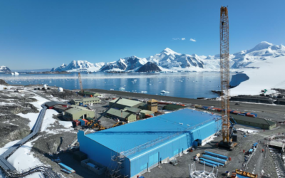 A large blue building with a snow covered mountain in the background