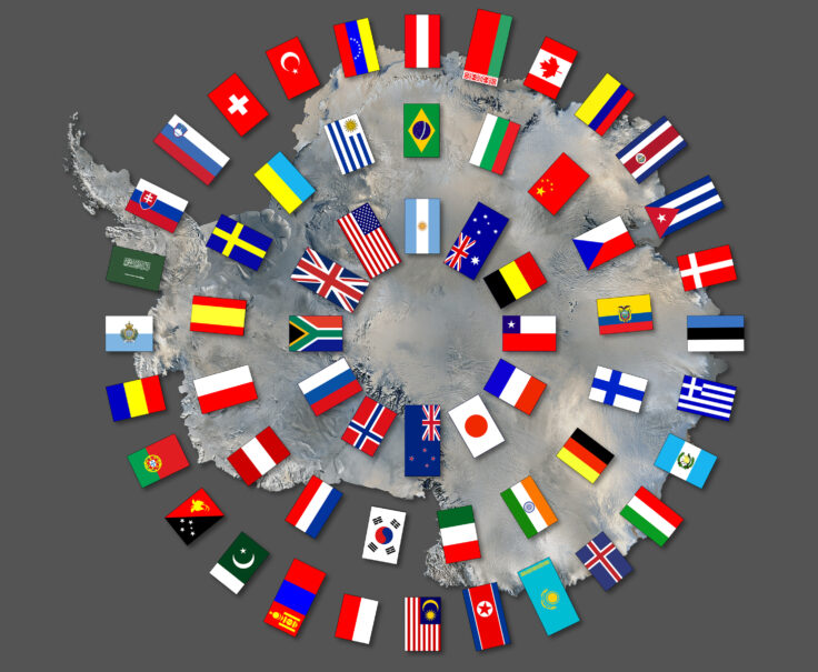 Map of Antarctica with flags of 57 signatories arranged in concentric circles over the top. On a grey background.