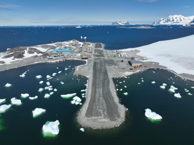 Rothera Research Station from above, showing the new Discovery building, a large blue building, and the resurfaced runway in the foreground.