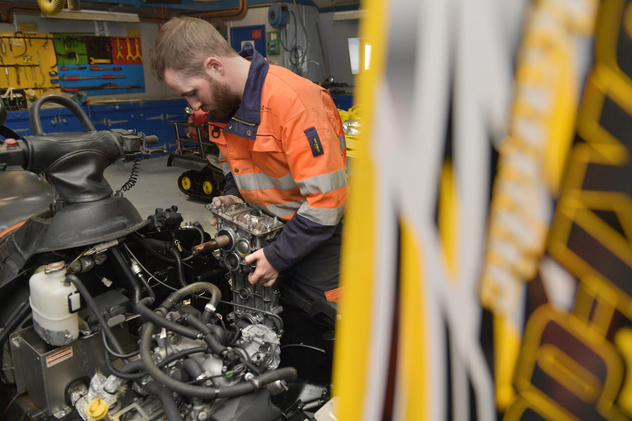 A man works on an engine in a workshop