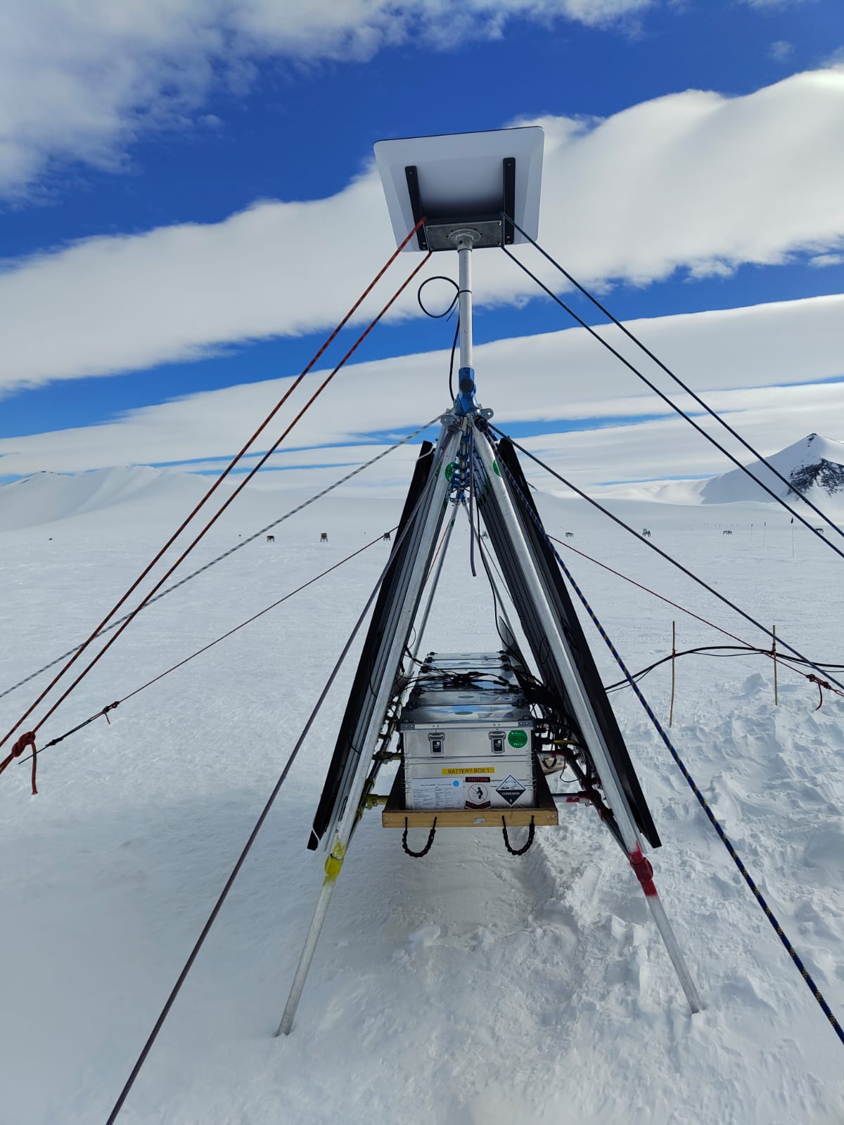 A tripod standing on top of an ice and snow covered ground